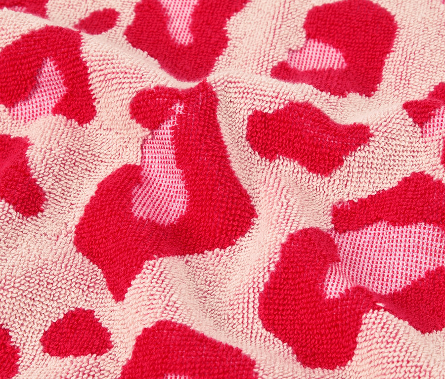Detailní záběr ručníku s růžovým leopardím vzorem.