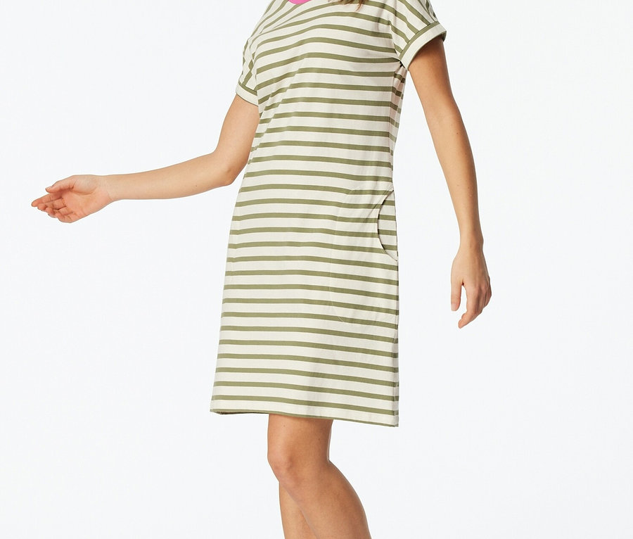 Žena má na sobě pruhované tričkové šaty s růžovými akcenty na výstřihu.