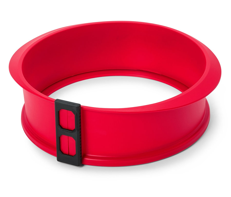 Červená, kulatá forma na dort s černým uzávěrem na bílém pozadí.