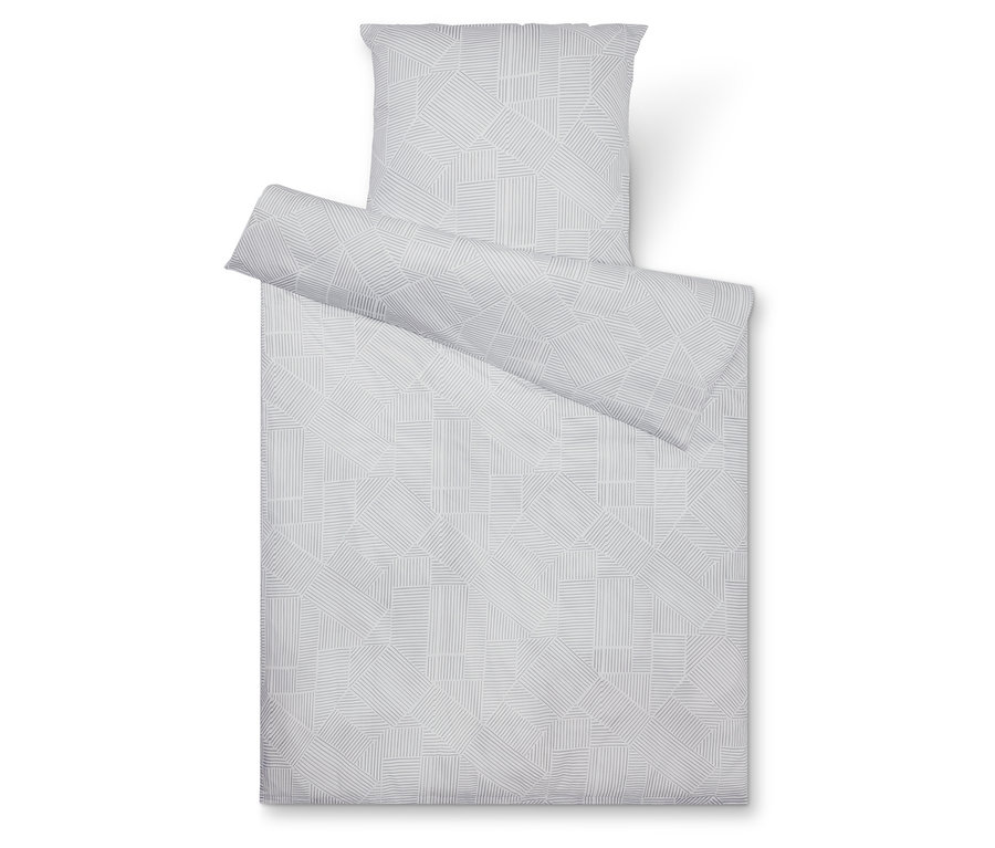 Pohled shora na šedou sadu ložního prádla s geometrickým vzorem, skládající se z povlaku na polštář, přikrývky a částečně srolovaného povlaku.