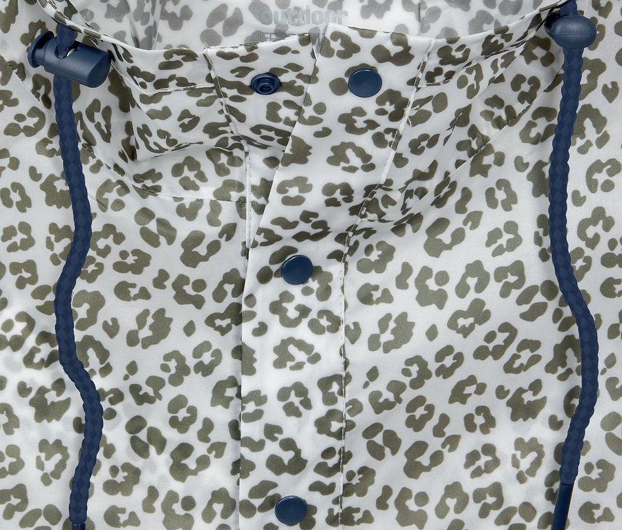 Detailní záběr na sbalitelné pončo do deště s leopardím vzorem, modrými knoflíky a stahovací šňůrkou.