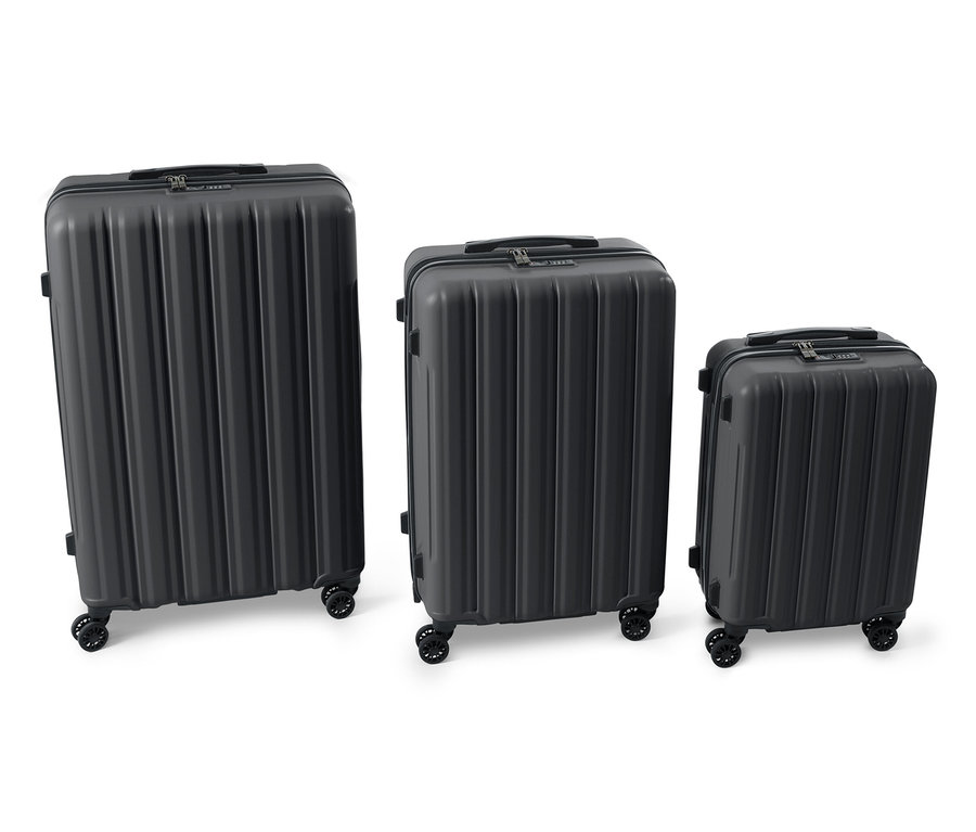 Tři černé kufry z tvrdé skořepiny různých velikostí vedle sebe.