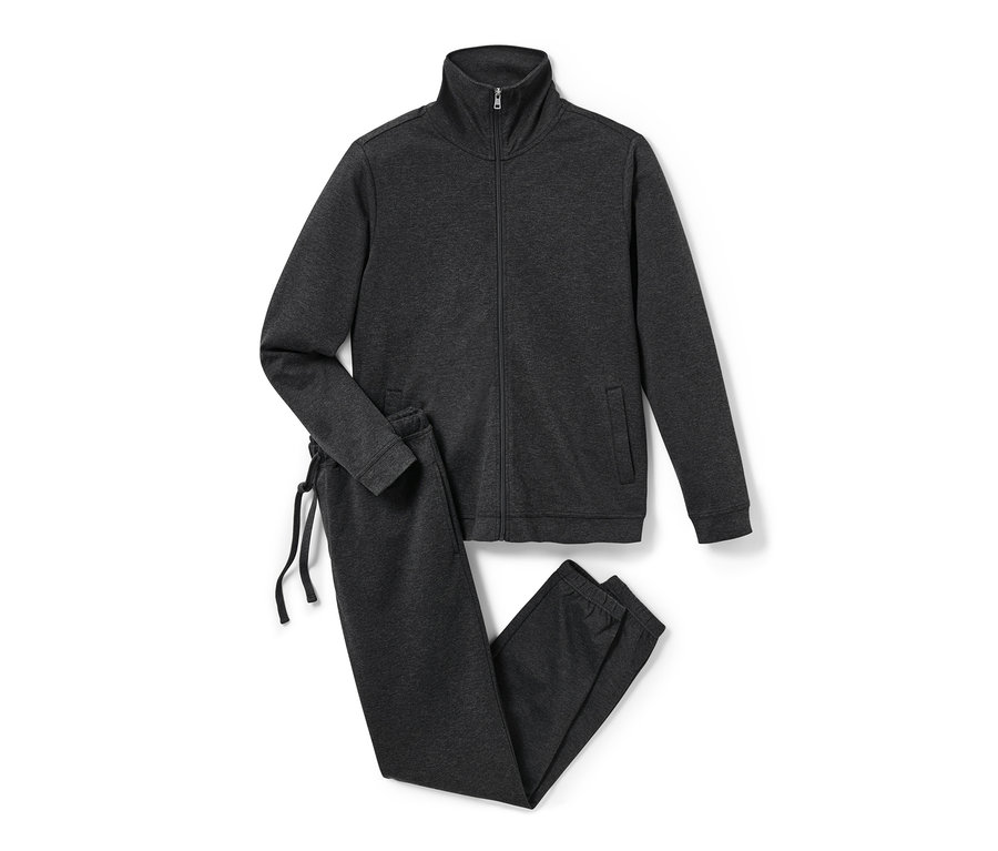 Šedá domácí souprava se zipem a kalhotami se stahovací šňůrkou leží na bílém pozadí.