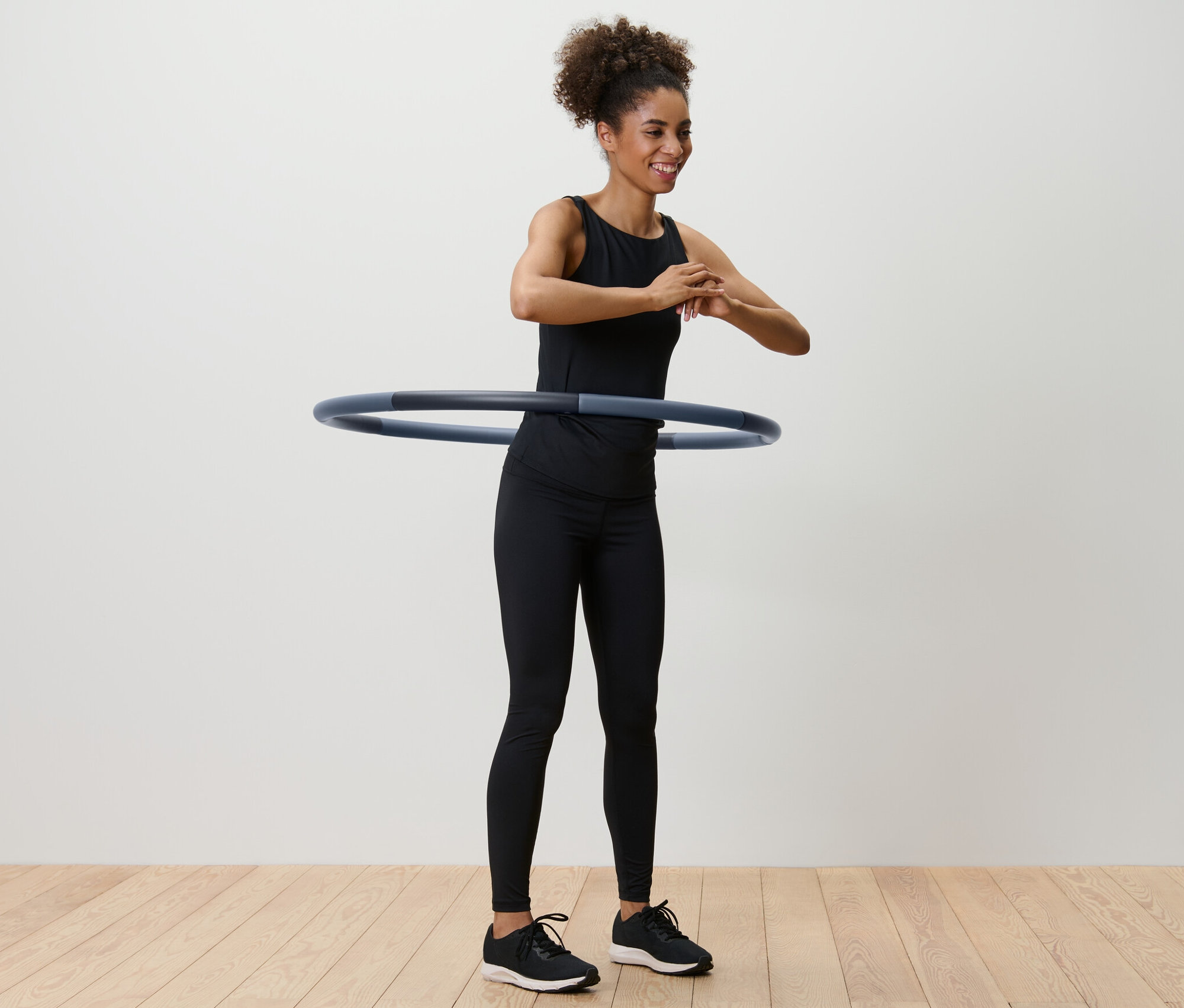 Žena točí gymnastickou obruč kolem pasu.