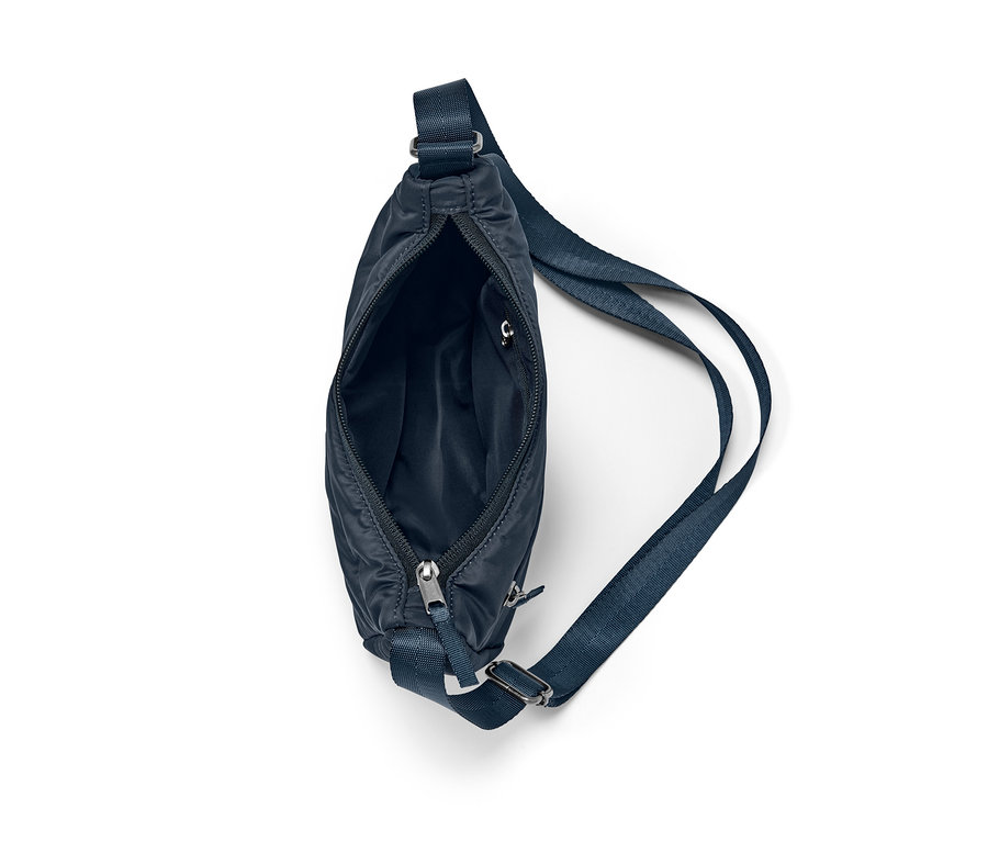 Detail modré tašky přes rameno s otevřeným zipem.