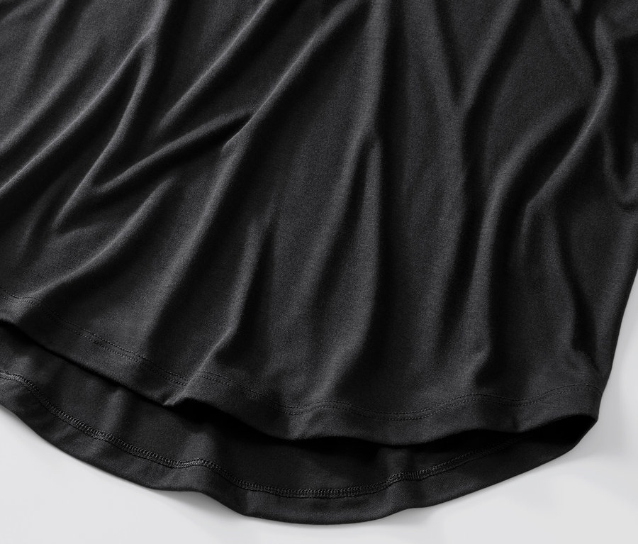 Detail černé, dlouhé košile.