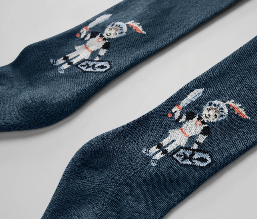 Detail dvou dětských punčocháčů s motivem rytíře.