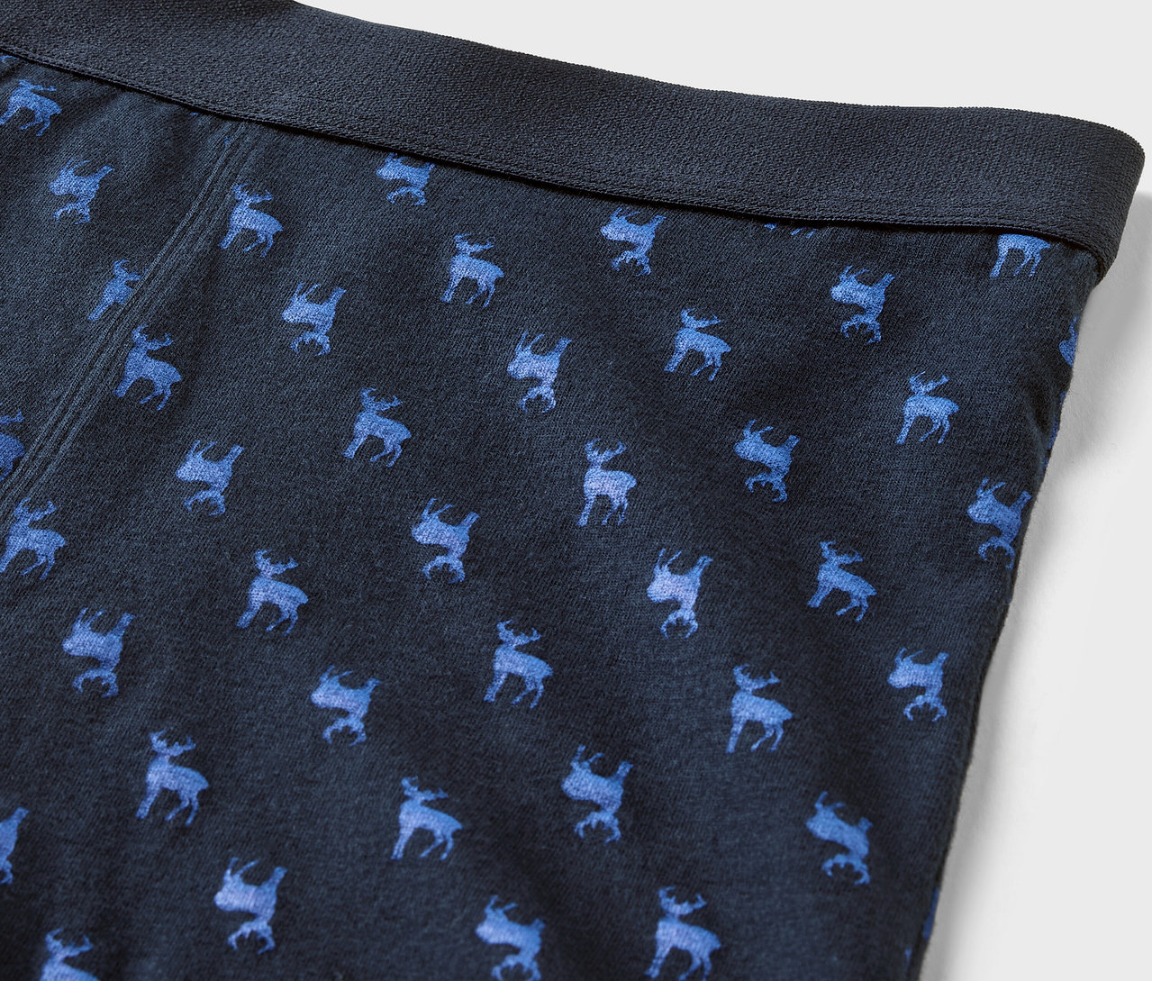 Detail modrých pánských boxerek s potiskem modrých losů a tmavě modrým pasem.