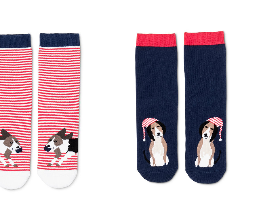 Dva páry protiskluzových ponožek. Jeden pár je červeno-bílý pruhovaný s potiskem psa. Druhý pár je tmavě modrý s červeným lemem a potiskem psa v čepici.