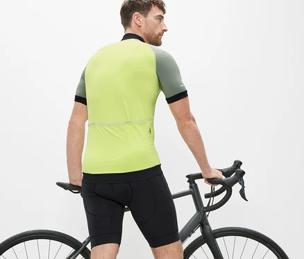 Muž stojí u kola a má na sobě cyklistické kalhoty.