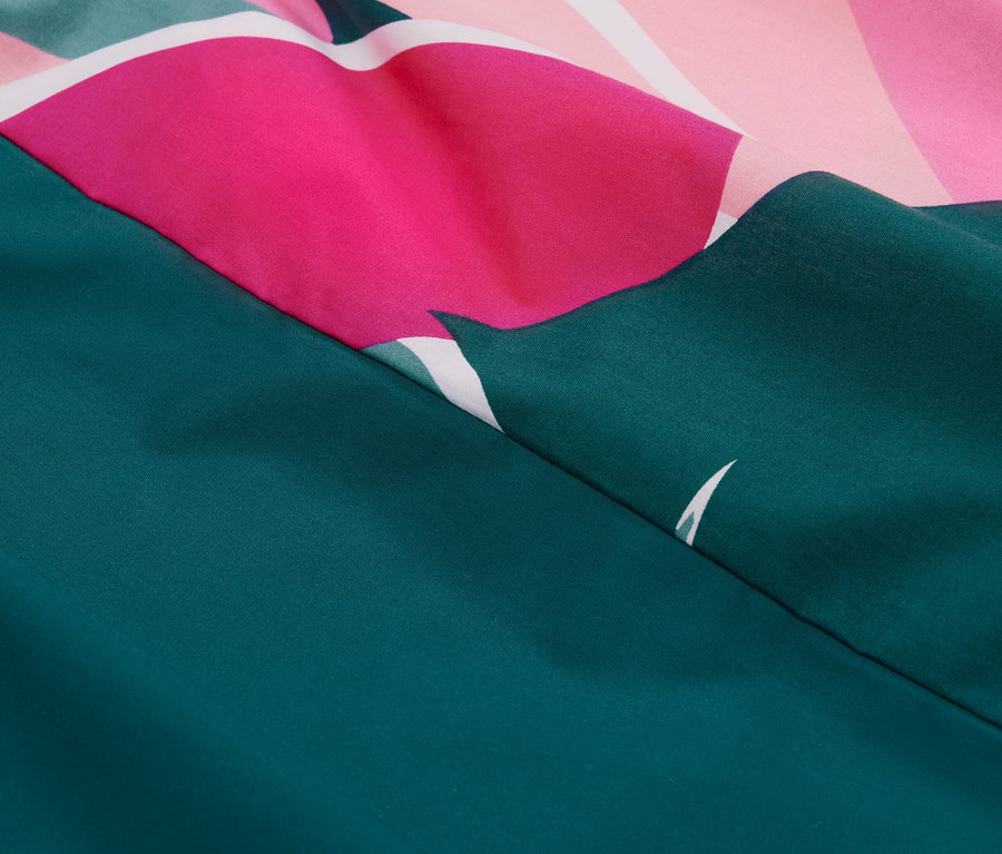 Detail perkálového povlečení se vzorem listů.