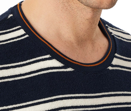 Detail muže s tmavě modrým pruhovaným svetrem s kulatým výstřihem.