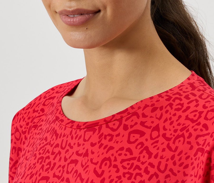 Detail horní části dámského červeného topu s potiskem.