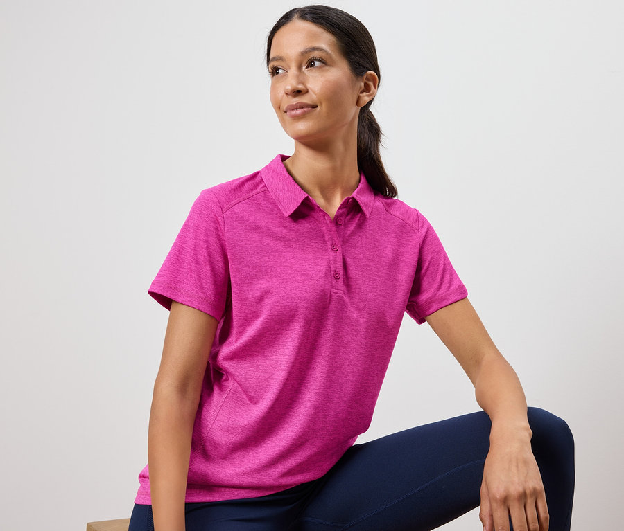 Žena má na sobě růžové polo tričko a tmavě modré legíny.