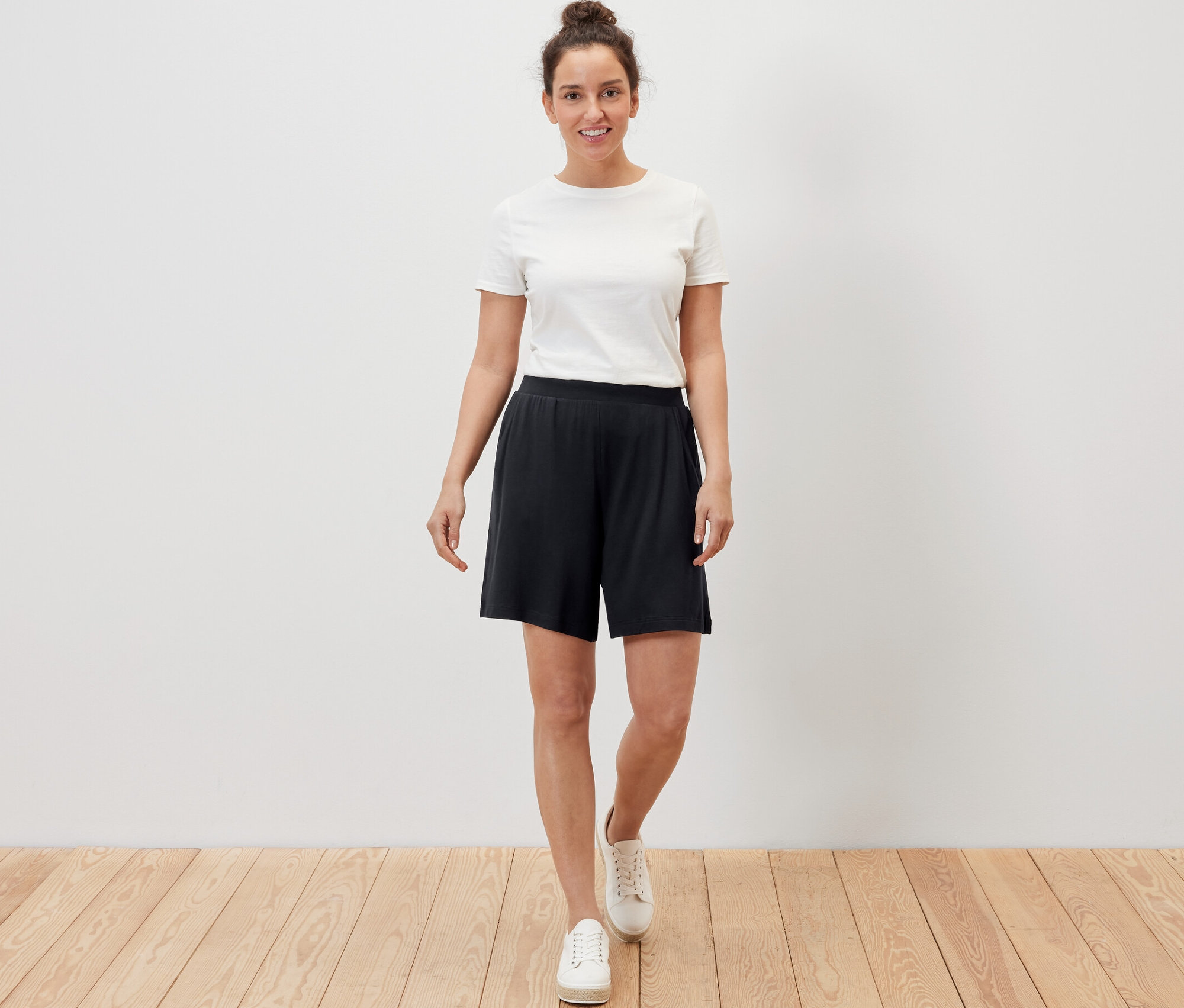 Žena má na sobě černé žerzejové šortky.