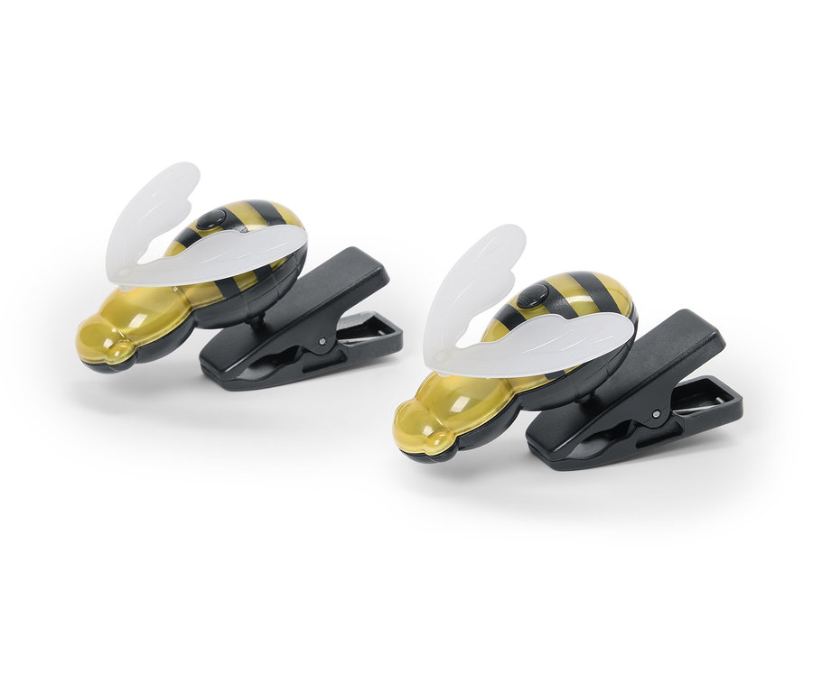 Dvě klipsové lampičky ve tvaru včel leží na bílém pozadí.