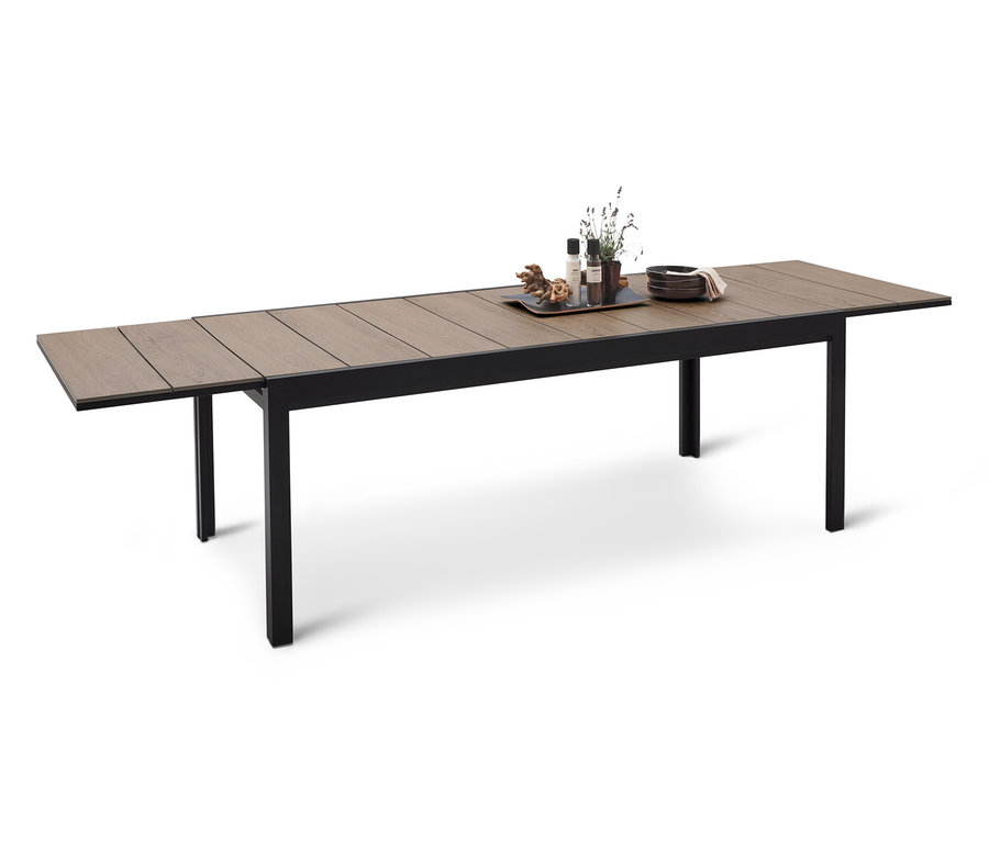 Dlouhý jídelní stůl s černým rámem a dřevěnou deskou, na které je podnos s dekoracemi.