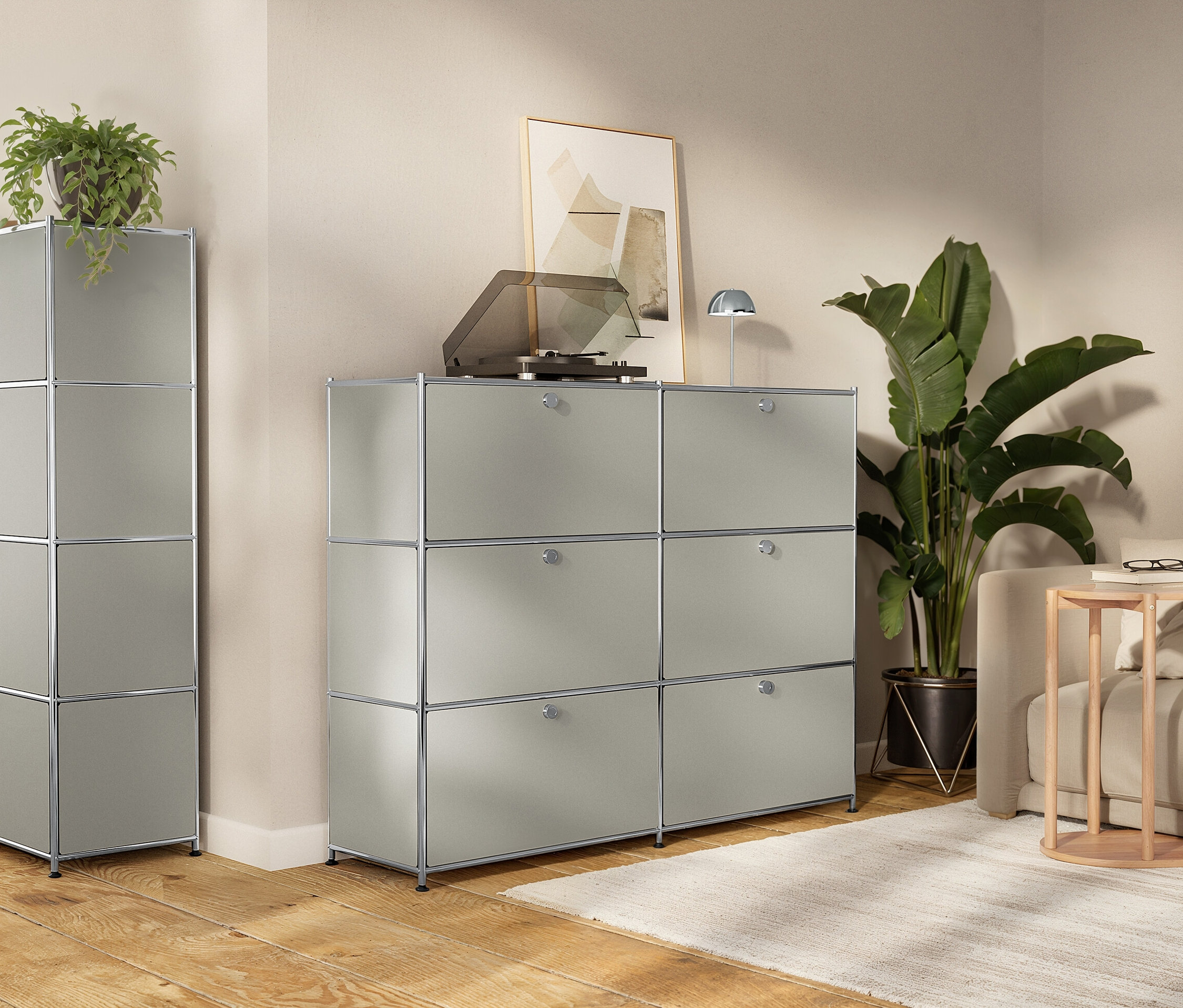 Obývací pokoj s modulárními šedými úložnými skříněmi, gramofonem, pokojovými rostlinami a pohovkou.