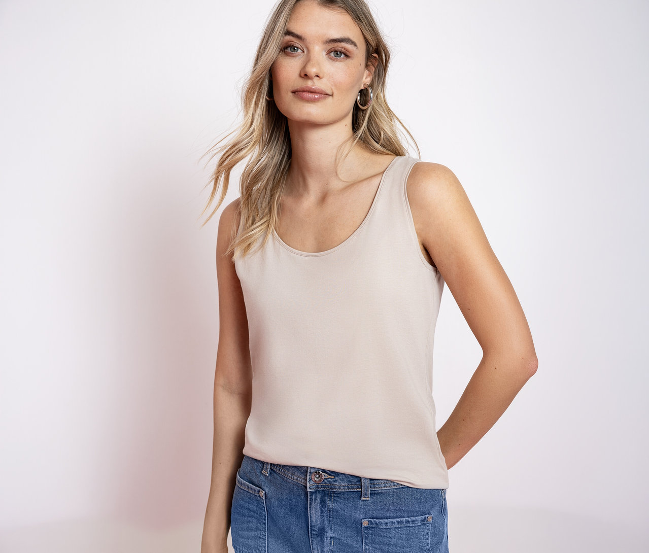 Blonďatá žena má na sobě top basic Street One a džíny.