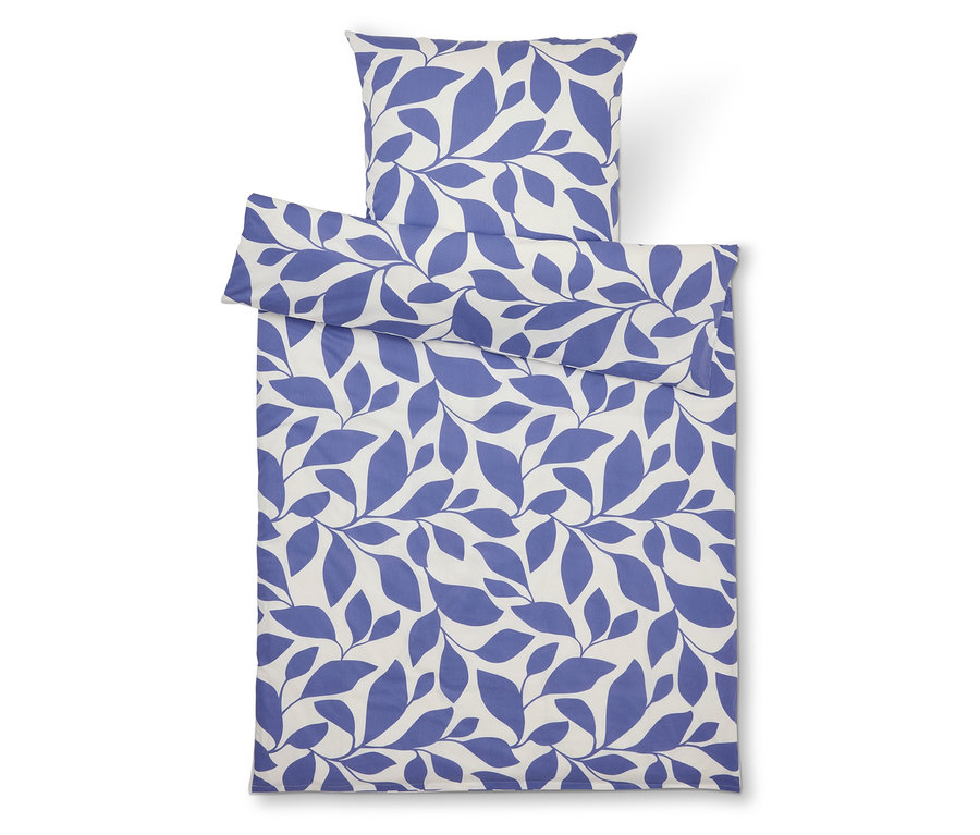 Sada ložního prádla s modrým potiskem listů na bílém pozadí, skládající se z povlaku na polštář a povlaku na přikrývku.