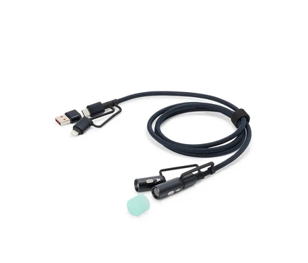 Modrý nabíjecí kabel s konektory USB, USB-C a Lightning, dvěma malými LED světly a silikonovým nástavcem leží na bílém pozadí.