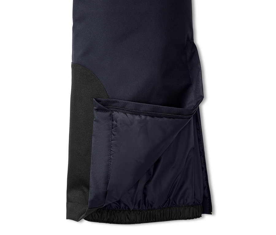 Detail lyžařských kalhot s rozepnutým zipem.