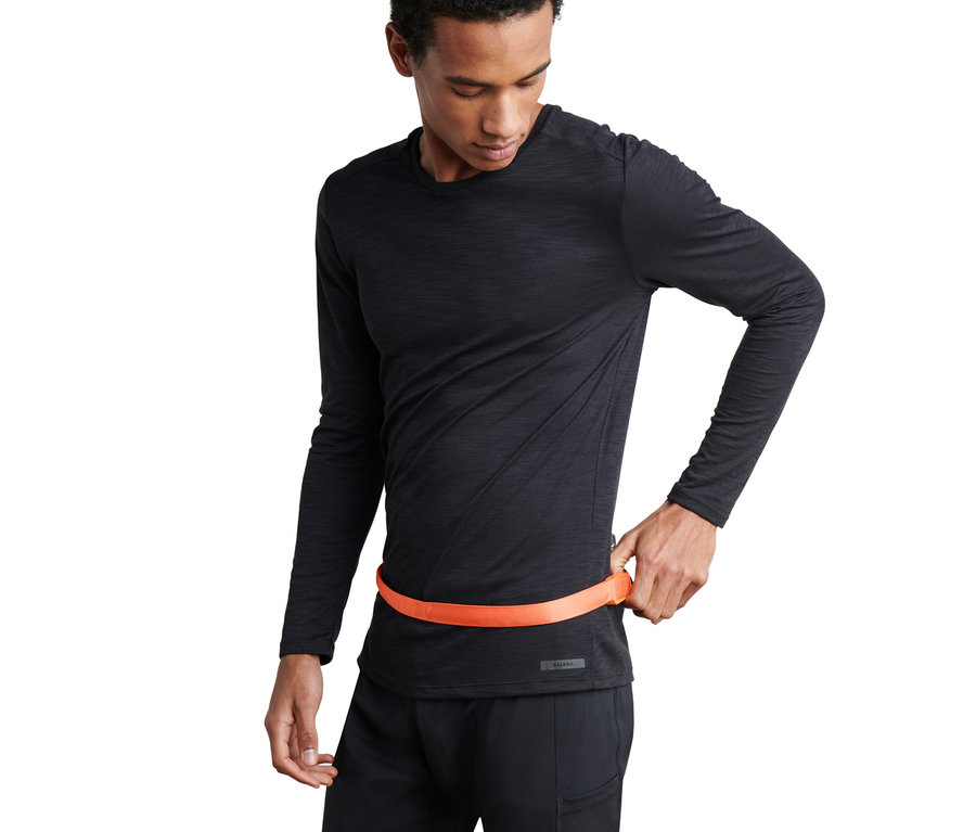 Muž si zapíná LED pásek kolem pasu.