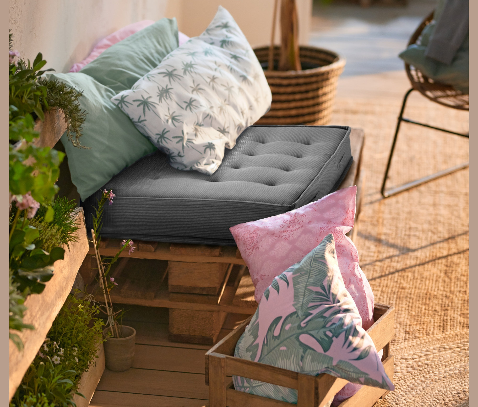 Venkovní posezení z palet s XL sedáky a dekoračními polštářky.