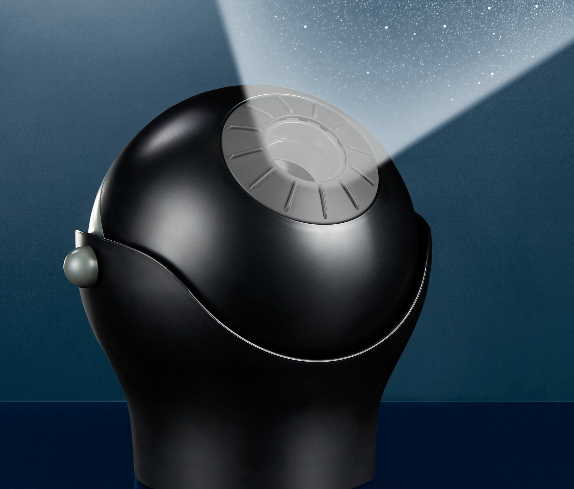 Černé domácí planetárium promítá hvězdy na stěnu.