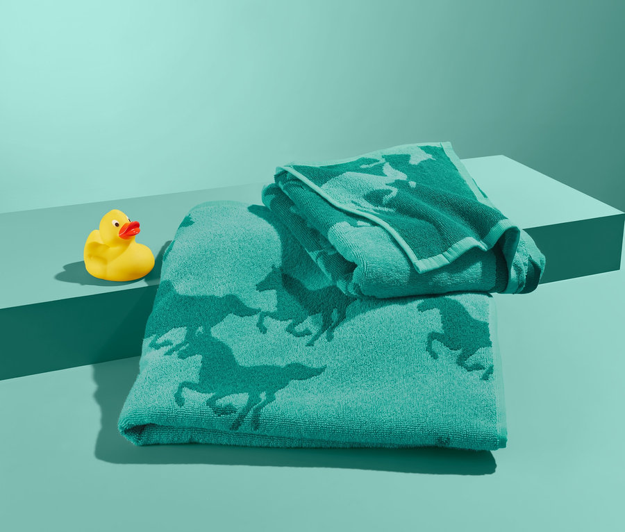 Sada ručníků s motivem koní a žlutá gumová kachnička na tyrkysovém pozadí.