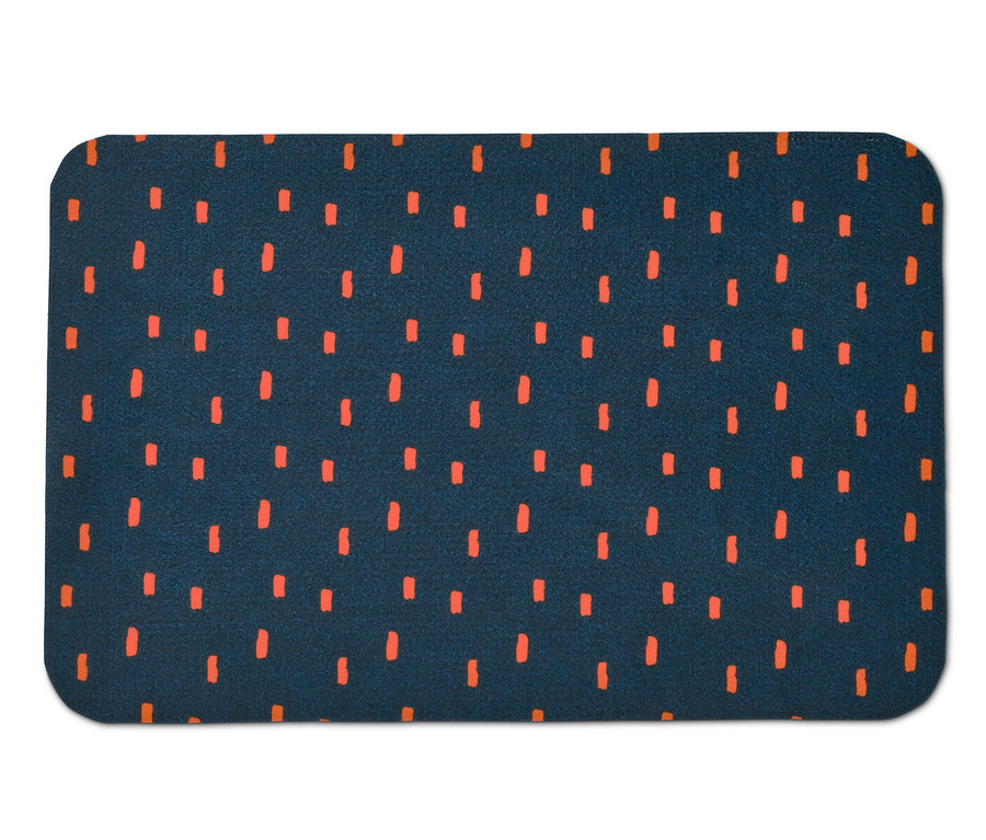 Tmavě modrá podložka pod misky s krmením s oranžovými vzory.