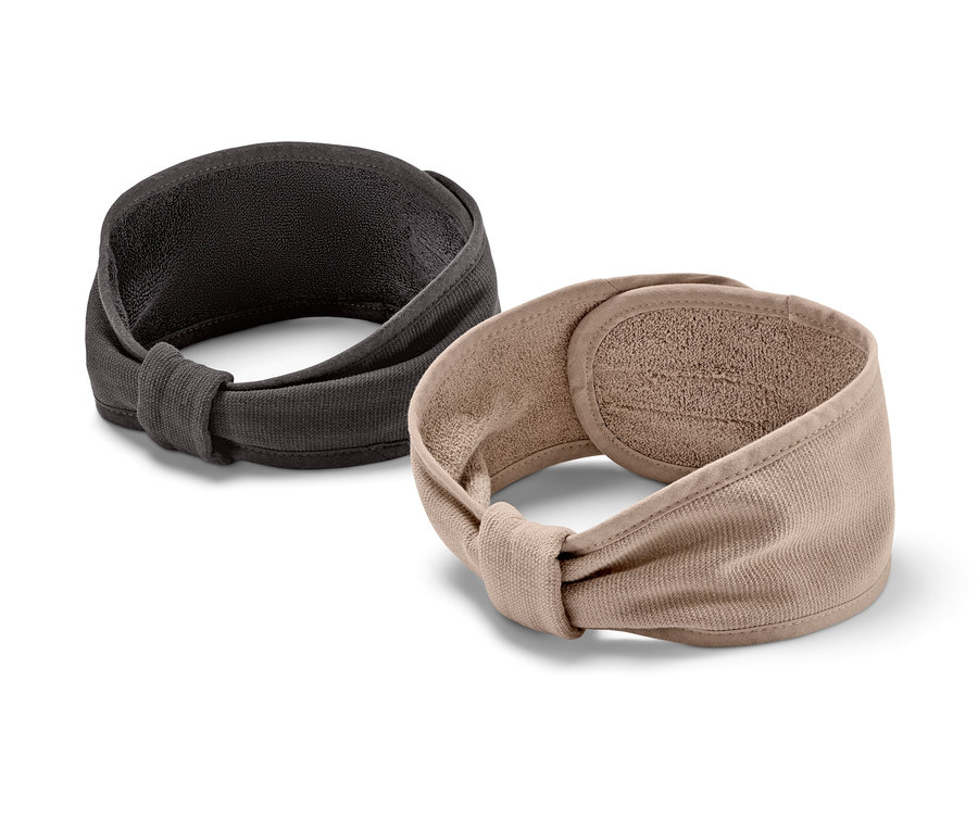 Dvě kosmetické čelenky, jedna černá a jedna hnědá, leží vedle sebe na bílém pozadí.