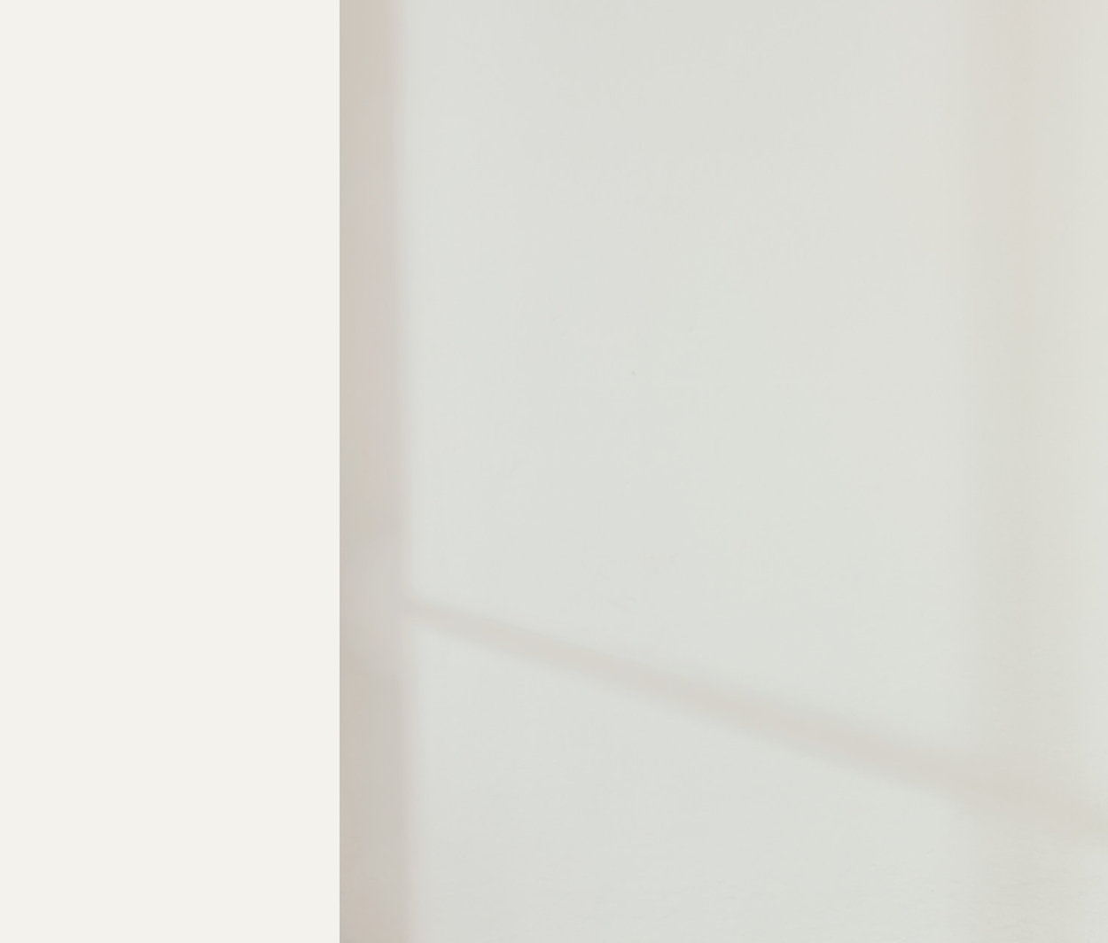 Žena stojí v místnosti a má na sobě světle béžové tričko a tepláky.