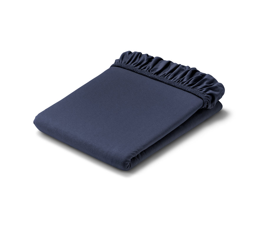 Složené modré žerzejové prostěradlo s gumou.