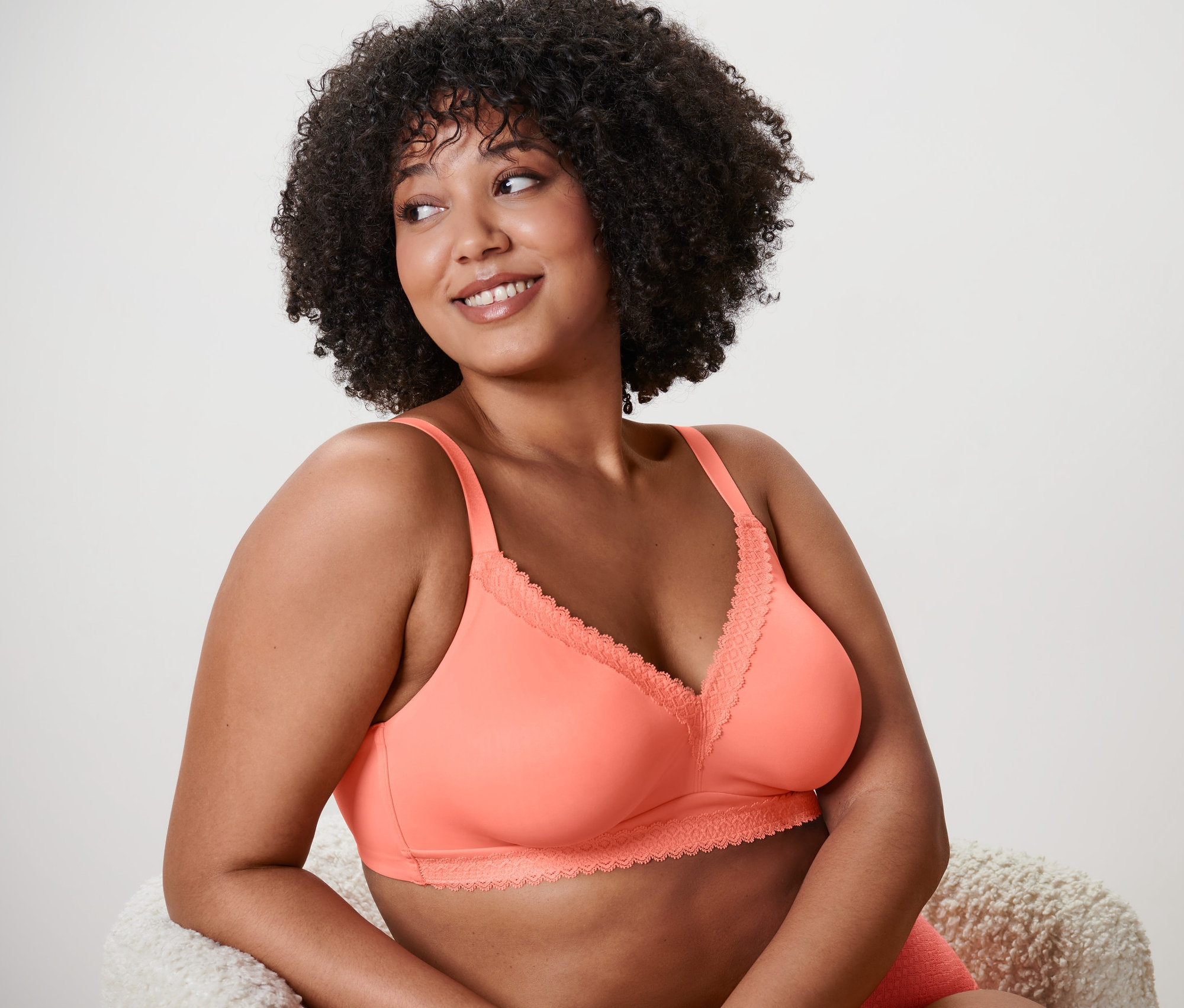 Žena s afro účesem má na sobě měkkou podprsenku.