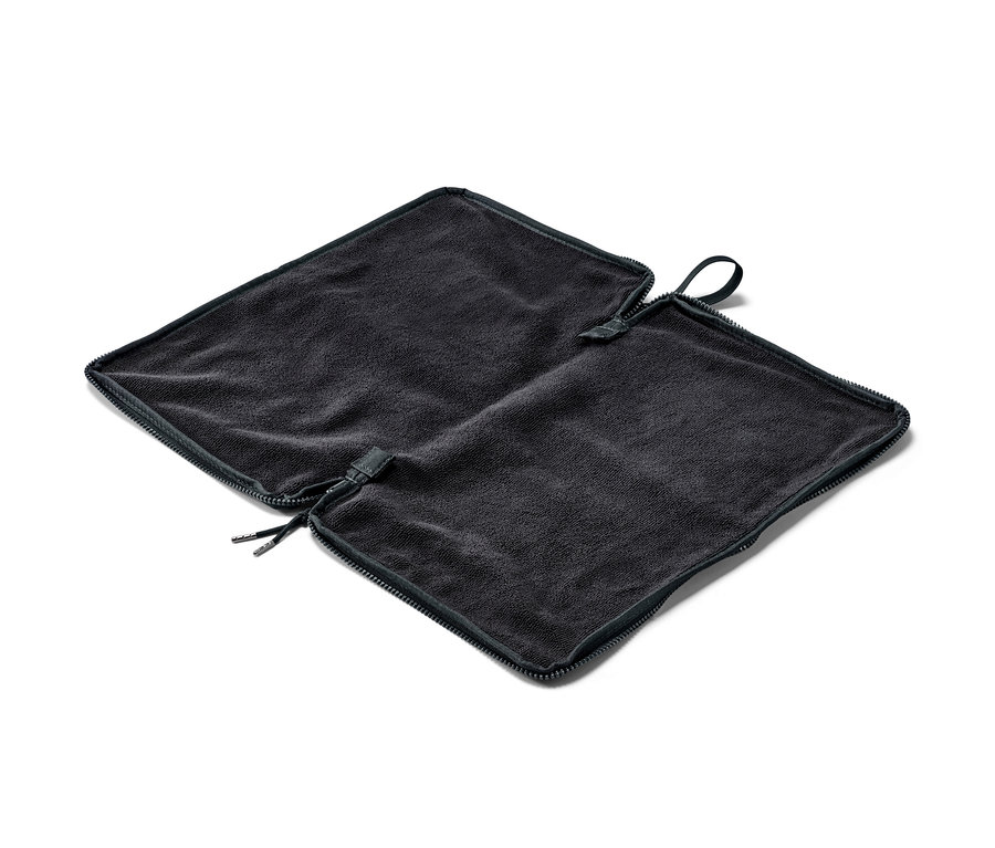 Černá podložka na přebalování a vak na mokré věci 2 v 1 rozložená na bílém pozadí.