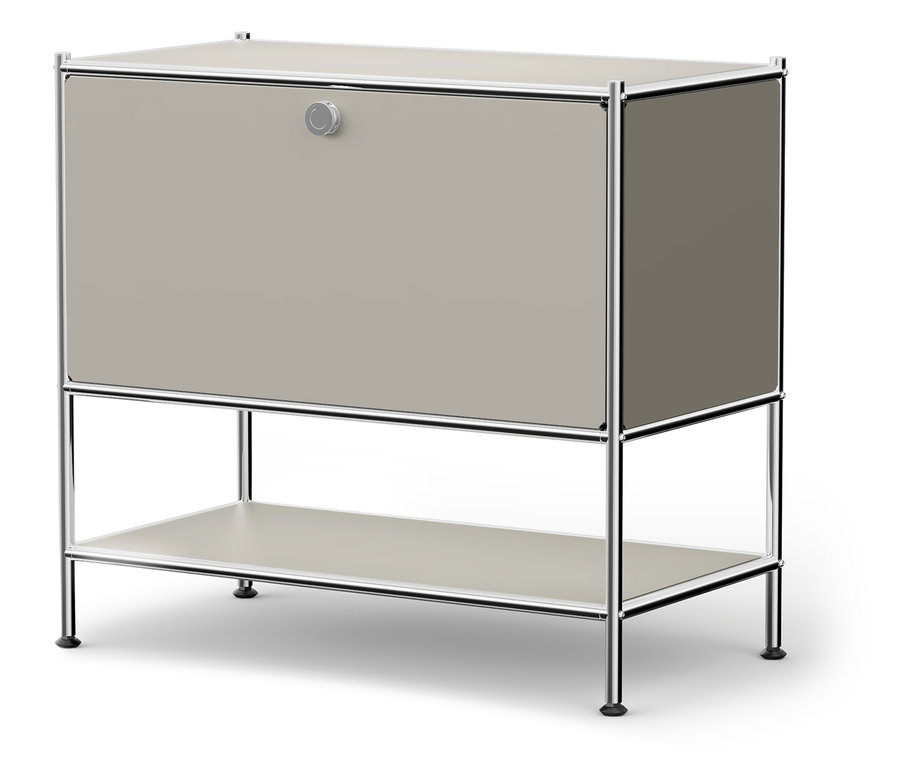 Šedá skříňka s chromovaným rámem a kulatým knoflíkem.