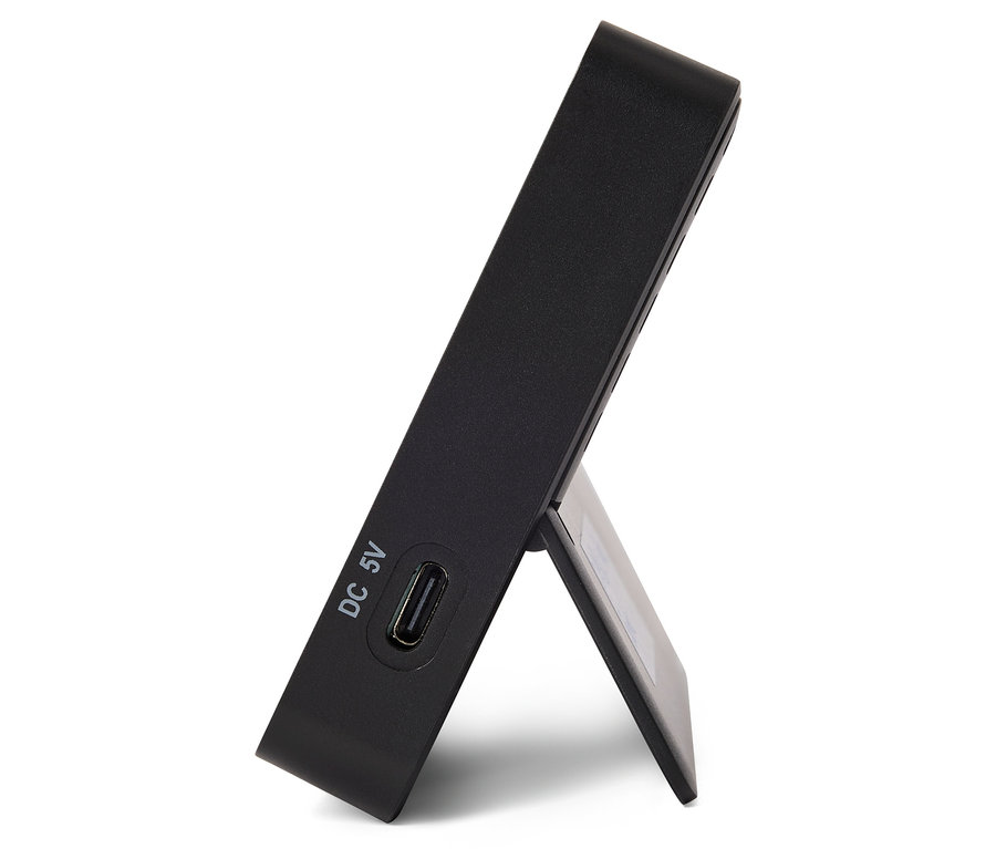 Černá elektronická čtečka s USB portem a stojánkem.