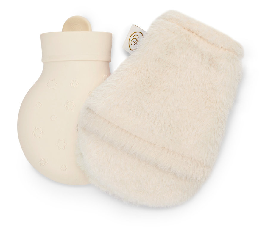 Krémová gumová láhev na horkou vodu s hvězdičkami vedle krémové chlupaté rukavice.