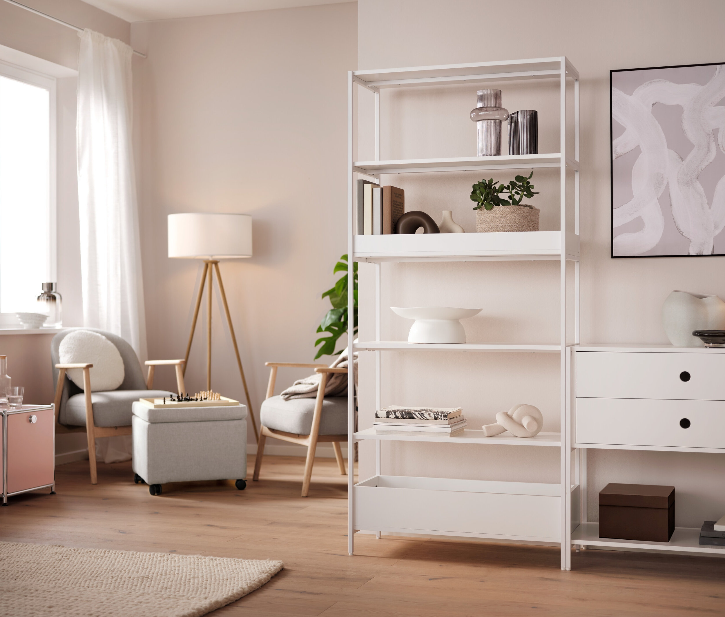 Šedá stolní LED lampa na baterie stojí na stole.