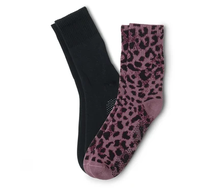 Pár ponožek, jedna černá a jedna fialová s leopardím vzorem, leží na sobě.