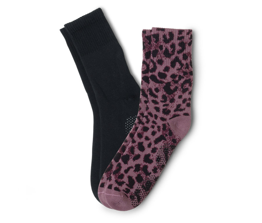 Pár ponožek, jedna černá a jedna fialová s leopardím vzorem, leží na sobě.