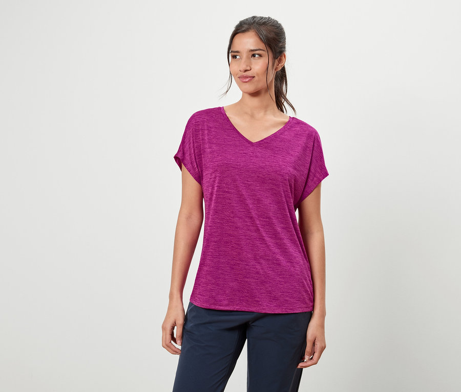 Žena má na sobě fialové tričko a modré kalhoty.