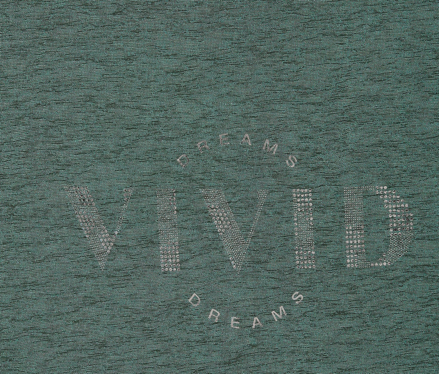 Detailní záběr mátově zelené látky se stříbrným nápisem „Vivid Dreams“.