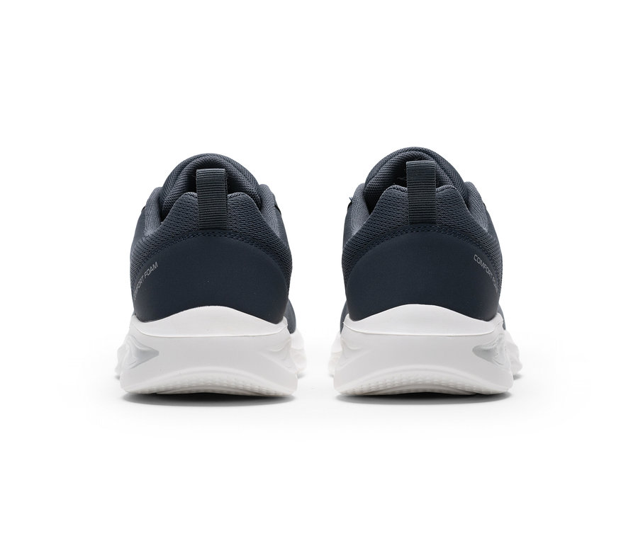 Dvě tmavě šedé sportovní boty s bílými podrážkami, viděné zezadu. Na levé botě je nápis „COMFORT FOAM“, na pravé „COMFORT“.