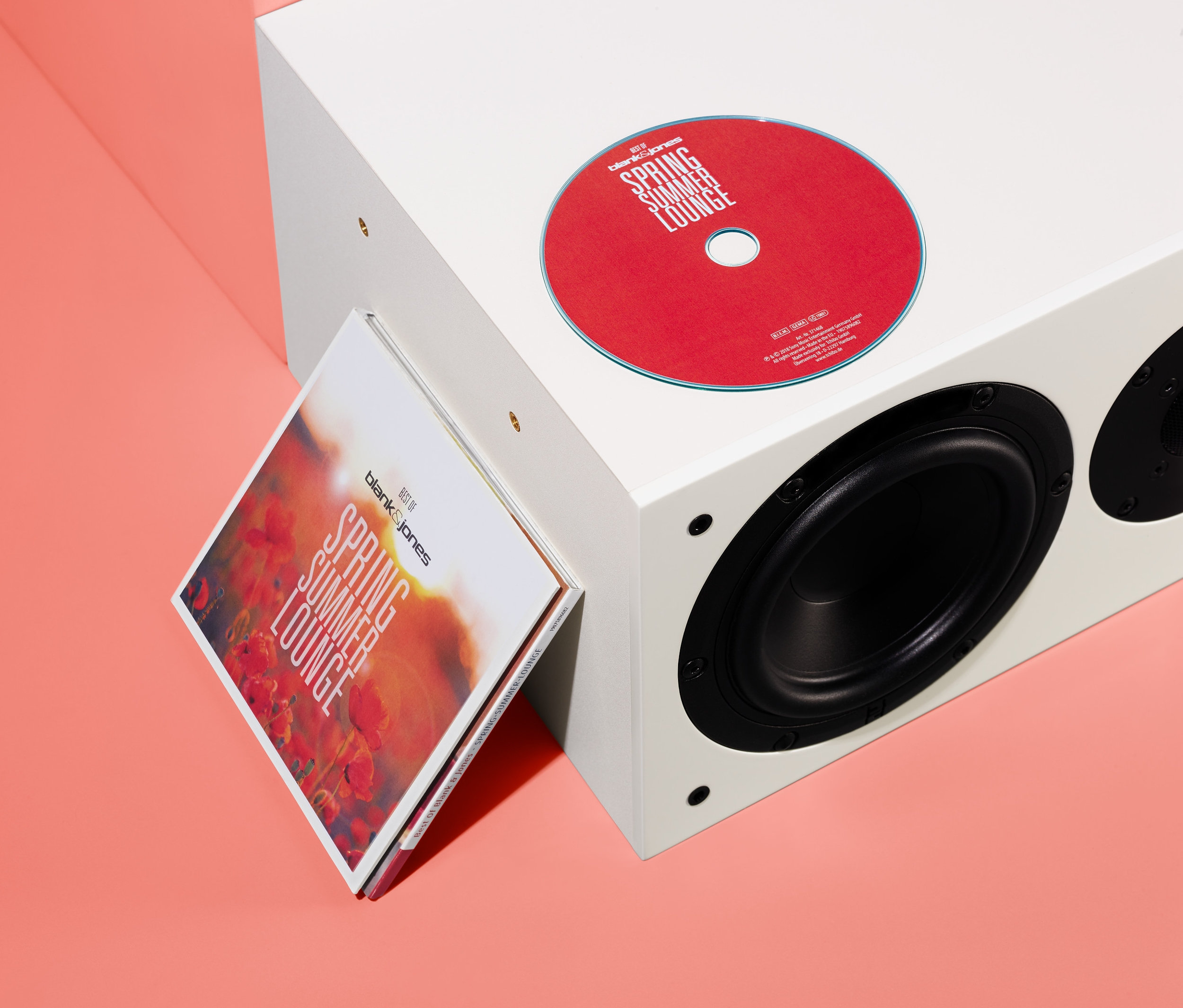 Červené CD a obal alba »Best of Blank & Jones: Spring Summer Lounge« opřené o bílý reproduktor.