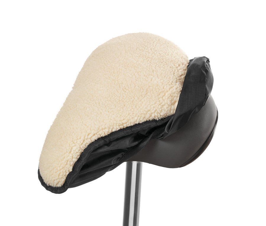 Detailní záběr na potah na cyklistické sedlo 2 v 1 s béžovým beránkem a černým nylonovým lemem.