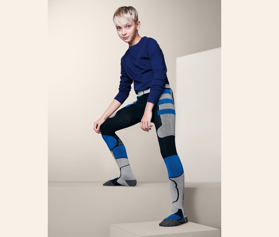 Mladík pózuje v lyžařských punčocháčích.