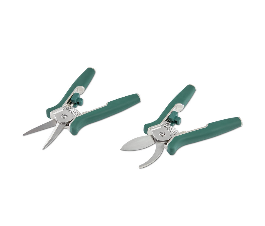 Dvoje nůžky na stříhání s zelenými rukojeťmi na bílém pozadí.