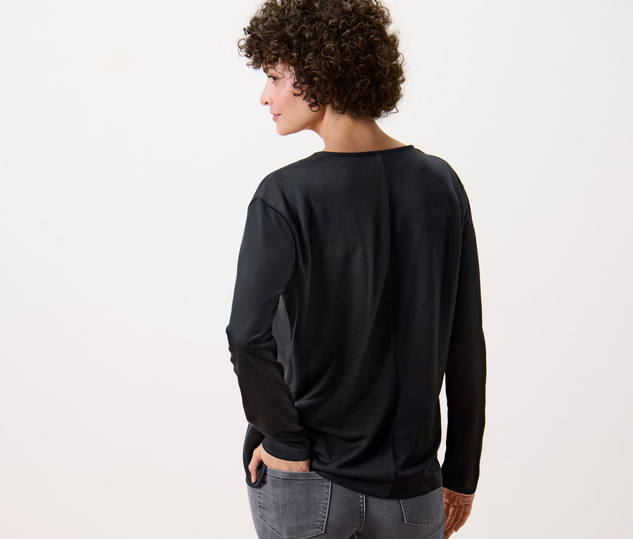 Žena zády k fotoaparátu má na sobě černé halenkové triko.